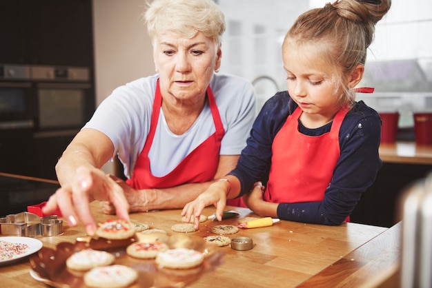Grand-mère et petite-fille décorant des cookies