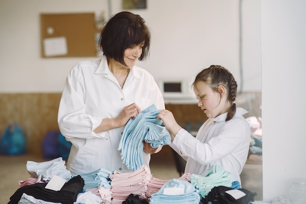 Grand-mère avec petite-fille mesurer le tissu pour la couture