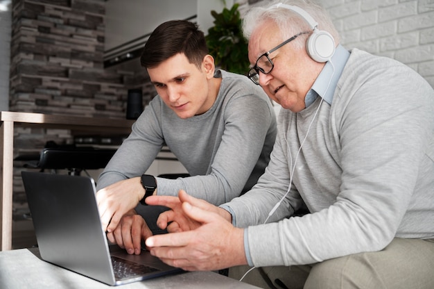 Grand-parent apprenant à utiliser un appareil numérique