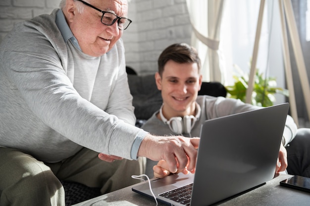 Grand-parent apprenant à utiliser un appareil numérique