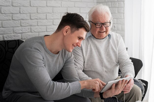 Grand-parent apprenant à utiliser un appareil numérique