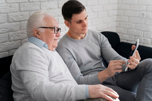 Grand-parent apprenant à utiliser un appareil numérique