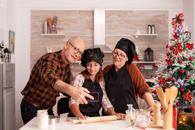 Photo gratuite grand-parent et enfant prenant le selfie le jour de noël