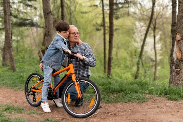 Grand-père apprenant à son petit-fils à faire du vélo