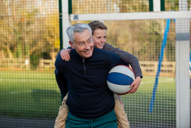 Grand-père de coup moyen portant un enfant