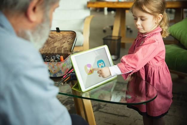 Grand-père et enfant jouant ensemble à la maison. Bonheur, famille, relation, concept d'éducation.