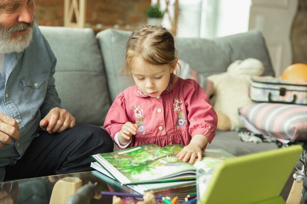 Grand-père et enfant jouant ensemble à la maison. Bonheur, famille, relation, concept d'éducation.