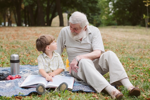 Grand-père et petit-fils lisant un pique-nique