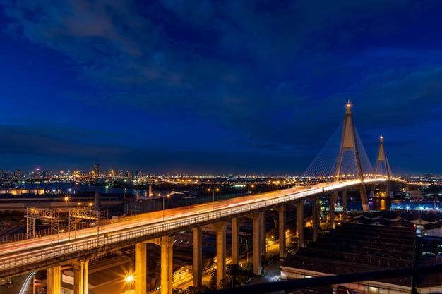 Grand pont suspendu au-dessus de la rivière Chao Phraya avec circulation au crépuscule