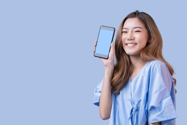 Grand succès promotion de paquet de vente sorti mode de vie causal asiatique geste de la main féminine présente carte de crédit et smartphone grand événement de promotion surprise avec fond de couleur bleue