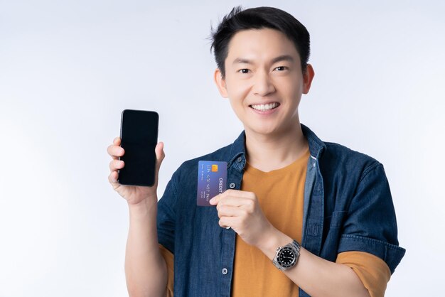 Grand succès vente paquet promotion sortie asiatique causale mode de vie masculin geste de la main présente carte de crédit et smartphone grande surprise promotion événement entreprise promotion concept d'assurance