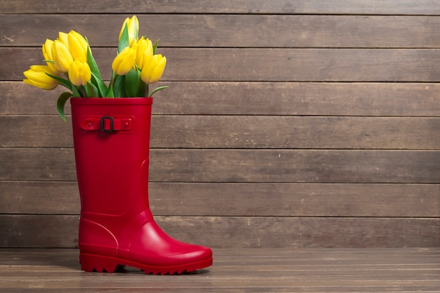 Photo gratuite grande composition avec les conseils, botte de l'eau et de jolies tulipes