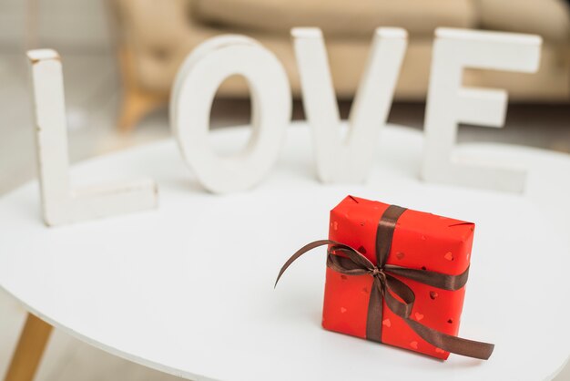 Grande inscription d&#39;amour blanche près d&#39;une boîte cadeau rouge