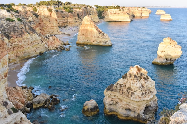 De grandes falaises qui sortent de l'eau pendant la journée