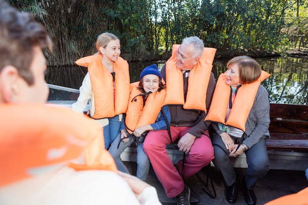 grands-parents retraités rire avec petits-enfants sur le bateau