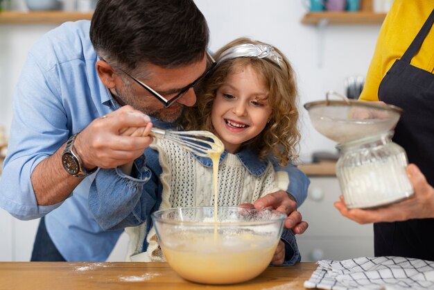 Grands-parents vue de face et fille dans la cuisine