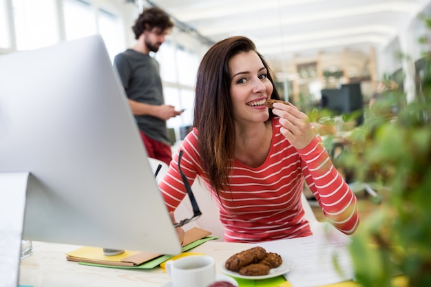 Photo gratuite graphiste femme ayant un cookie