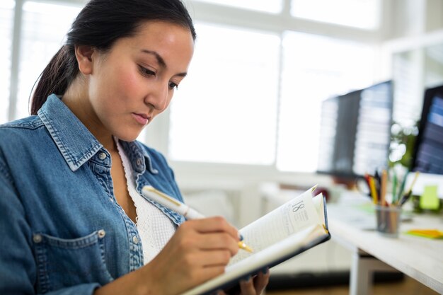 graphiste Femme écrivant sur un journal