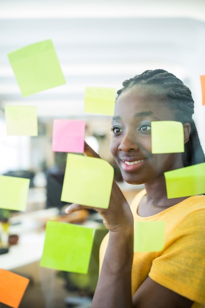 graphiste Femme regardant les notes collantes