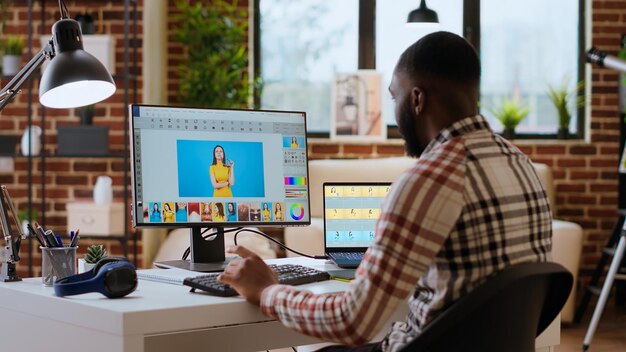 Un graphiste indépendant édite des photos sur un ordinateur moderne.