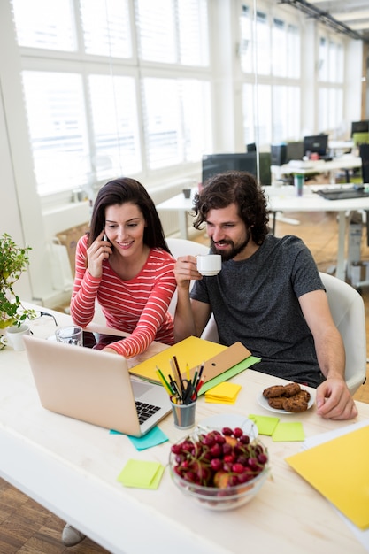 graphistes masculins et féminins utilisant un ordinateur portable