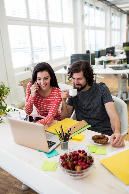 graphistes masculins et féminins utilisant un ordinateur portable