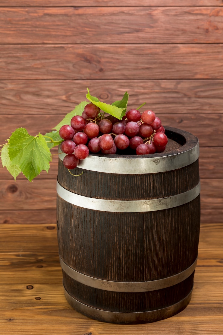 Photo gratuit grappe de raisin sur tonneau en bois