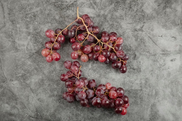 Grappe de raisins mûrs frais rouges sur une surface en marbre.