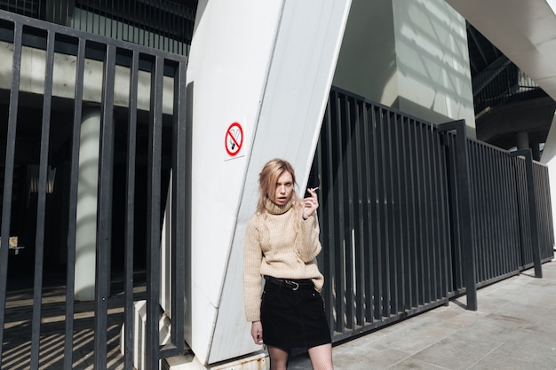 Grave jeune femme blonde avec cigarette