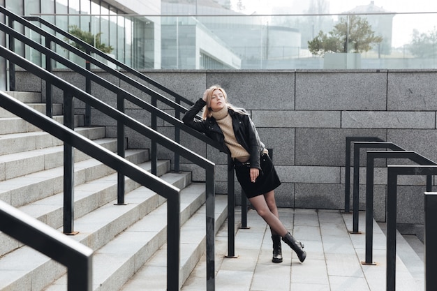 Grave jeune femme blonde à l'extérieur tenant la cigarette.