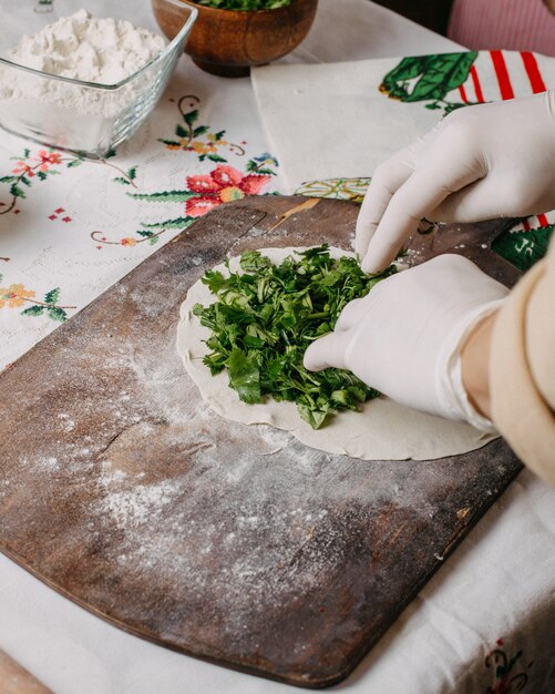 Greenies qutab en train de faire cuire la pâte d'herbes vertes sur un bureau rustique en bois brun