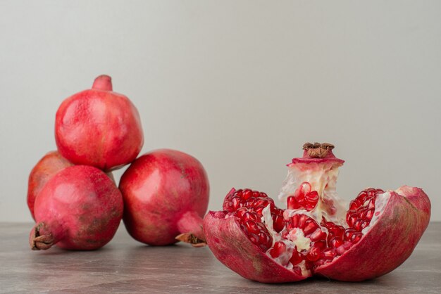 Grenades mûres et graines sur table en marbre.