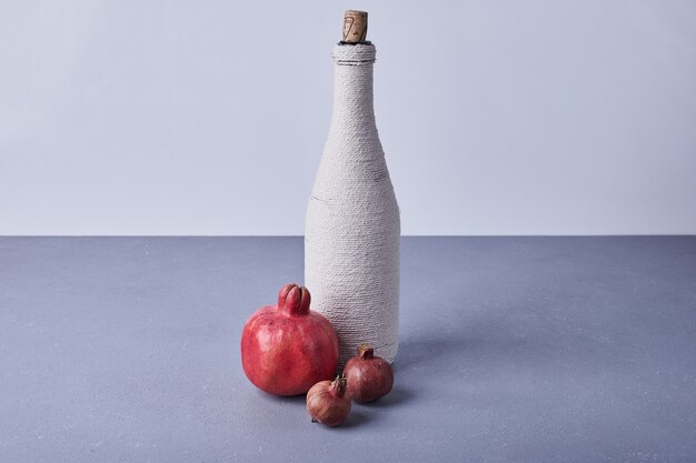 Grenades rouges avec une bouteille de vin.