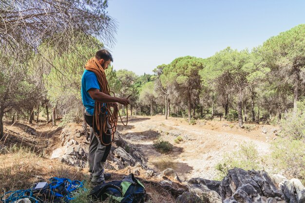 Grimpeur avec corde et sacs à dos au sol