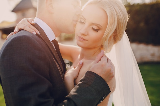 Groom embrasser la joue de sa femme au coucher du soleil