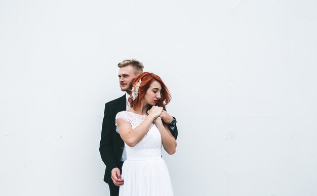 Groom étreindre son épouse avec un fond blanc