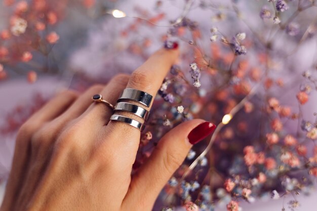 Gros coup de doigts de main de femme portant deux anneaux