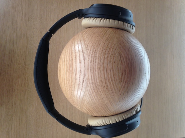Photo gratuite gros coup d'écouteurs noirs sur une boule en bois