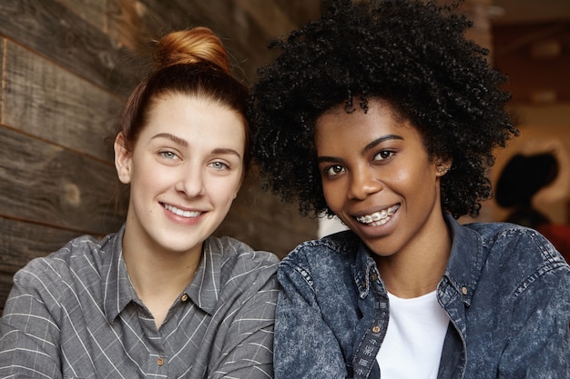 Gros coup franc de femme heureuse avec des cheveux bouclés et des accolades passer du bon temps avec sa petite amie rousse