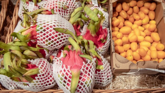 Gros fruit du dragon et kinkan sur un comptoir de supermarché.