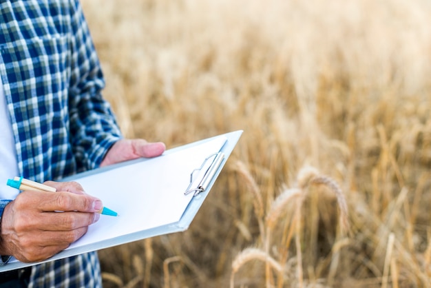 Gros homme prenant des notes sur un presse-papiers