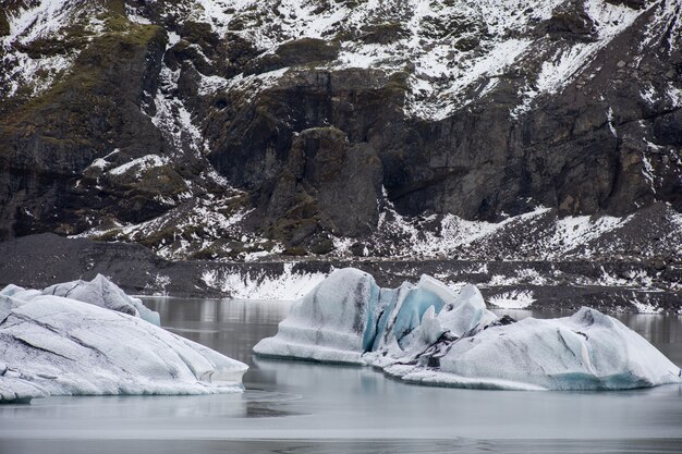 De gros morceaux de glace d'eau douce dans le lac gelé entouré de montagnes rocheuses