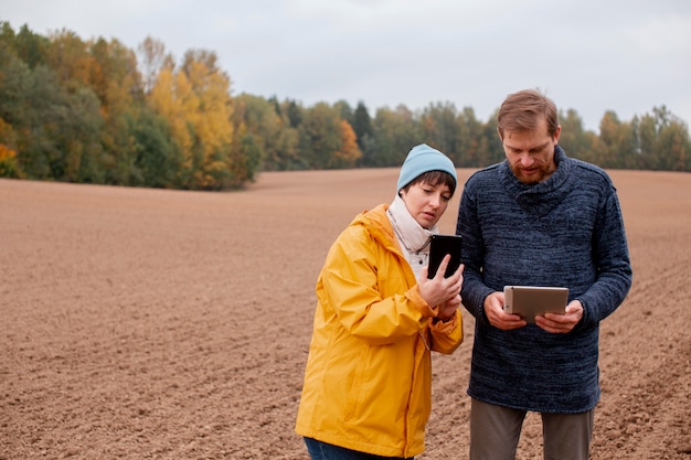 Photo gratuite gros plan sur un agriculteur à l'aide d'un appareil numérique