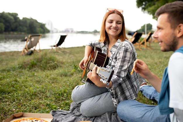 Gros plan d'amis assis sur l'herbe