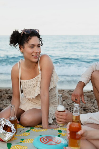 Gros plan d'amis assis sur la plage