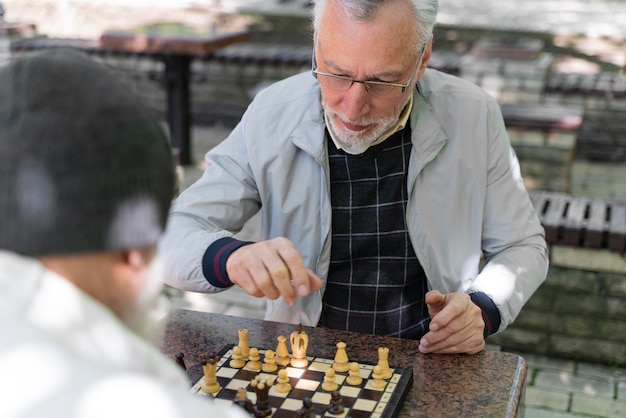 Gros plan des amis jouant aux échecs à l'extérieur