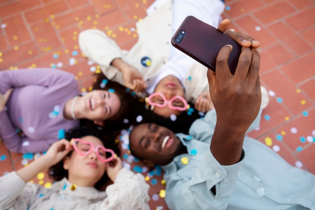 Photo gratuite gros plan des amis sur le sol en prenant un selfie