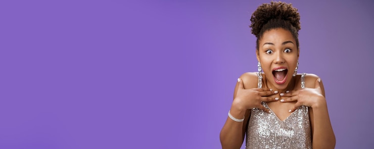 Photo gratuit gros plan amusé choqué glamour magnifique fille afro-américaine recevoir une surprise parfaite pointant la sienne