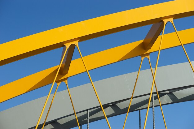 Gros plan d'un arc en métal jaune sous un ciel bleu