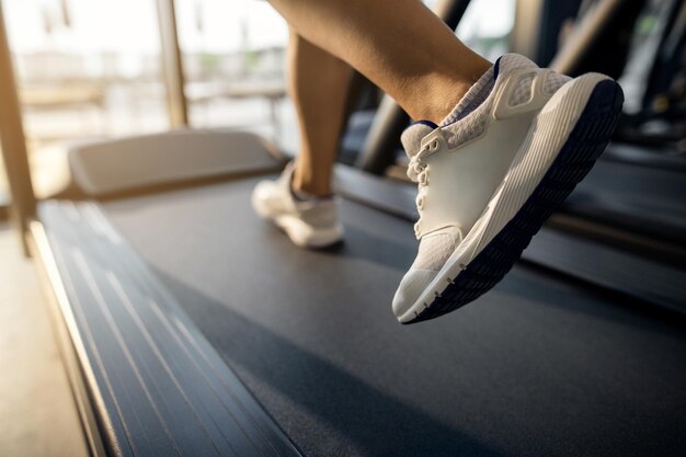 Gros plan sur une athlète féminine courant sur un tapis roulant dans une salle de sport